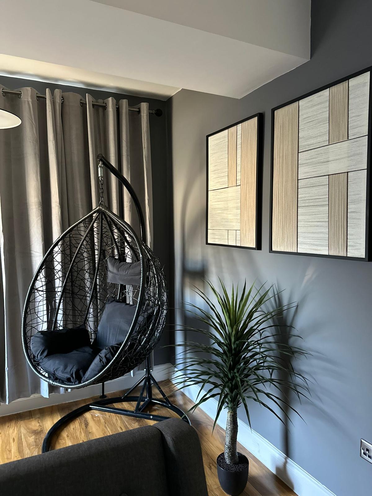 Decorated living room with painted grey walls and wood flooring